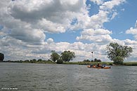 Wir paddeln berwiedend durch eine dnn besiedelte Wiesenlandschaft.